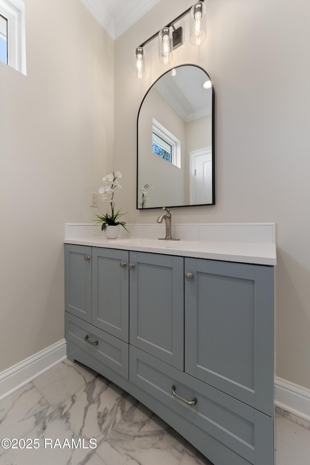 bathroom featuring marble finish floor, baseboards, crown molding, and vanity