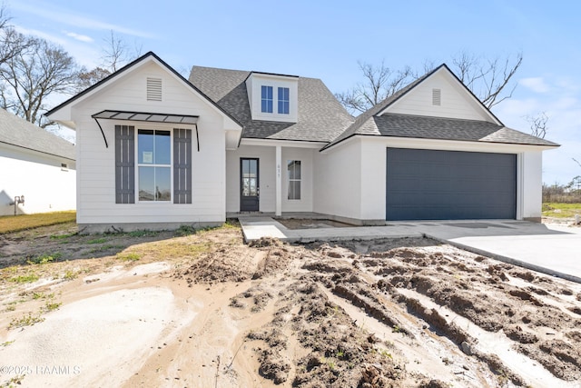 view of front facade with a shingled roof, driveway, and an attached garage