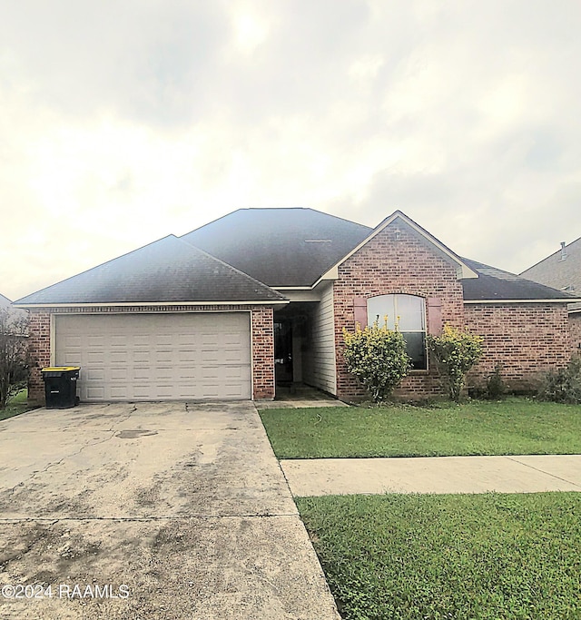 view of front of home with a front yard and a garage