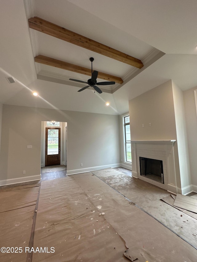 unfurnished living room with beam ceiling, ceiling fan, and a healthy amount of sunlight