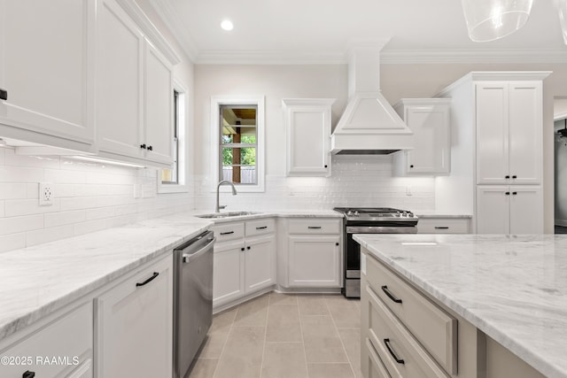 kitchen with white cabinets, a sink, stainless steel appliances, decorative backsplash, and light tile patterned floors