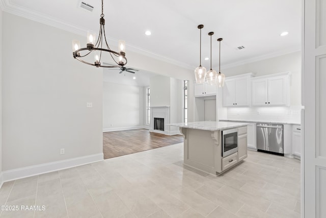 kitchen featuring crown molding, stainless steel dishwasher, built in microwave, and white cabinetry