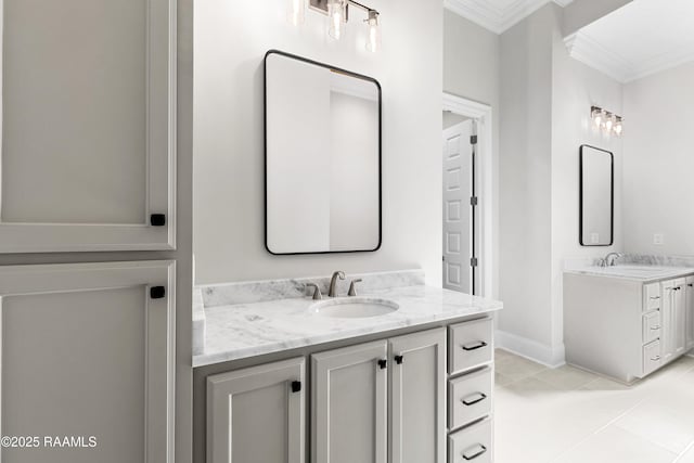 full bath with crown molding, a sink, baseboards, and two vanities