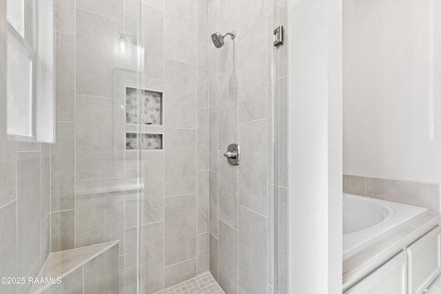 bathroom featuring a garden tub and a stall shower