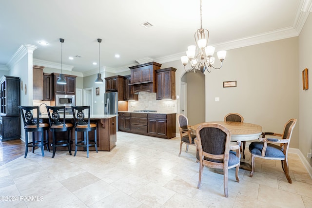 kitchen featuring dark brown cabinetry, stainless steel appliances, decorative light fixtures, an inviting chandelier, and a center island