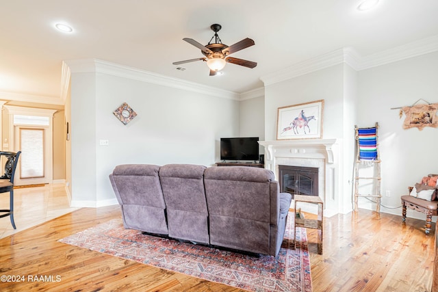 living room featuring ceiling fan, light hardwood / wood-style floors, and ornamental molding