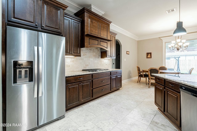 kitchen with light stone countertops, a notable chandelier, dark brown cabinets, appliances with stainless steel finishes, and ornamental molding