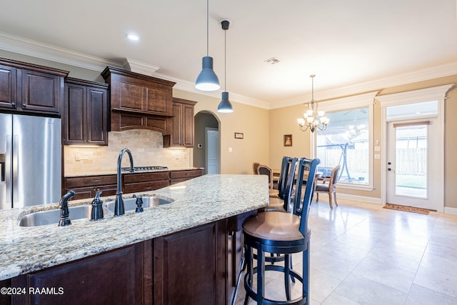 kitchen featuring dark brown cabinetry, light stone countertops, hanging light fixtures, stainless steel fridge with ice dispenser, and a notable chandelier