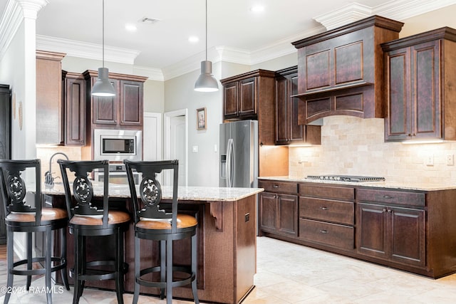 kitchen featuring decorative light fixtures, stainless steel appliances, light stone counters, and ornamental molding