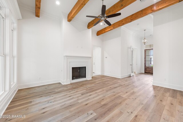 unfurnished living room with beamed ceiling, a brick fireplace, light wood-style floors, and ceiling fan