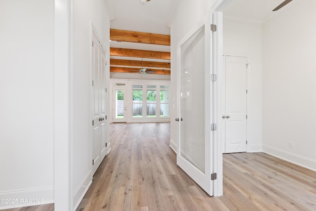 hall featuring beamed ceiling, light wood-style floors, and baseboards