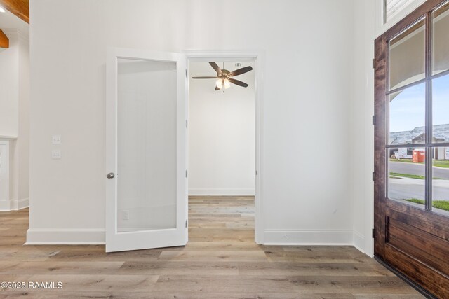 entrance foyer featuring baseboards, a ceiling fan, and wood finished floors