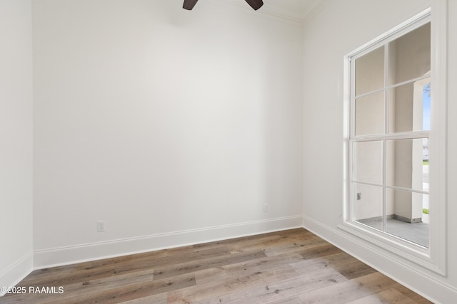 empty room featuring baseboards, a ceiling fan, wood finished floors, and ornamental molding