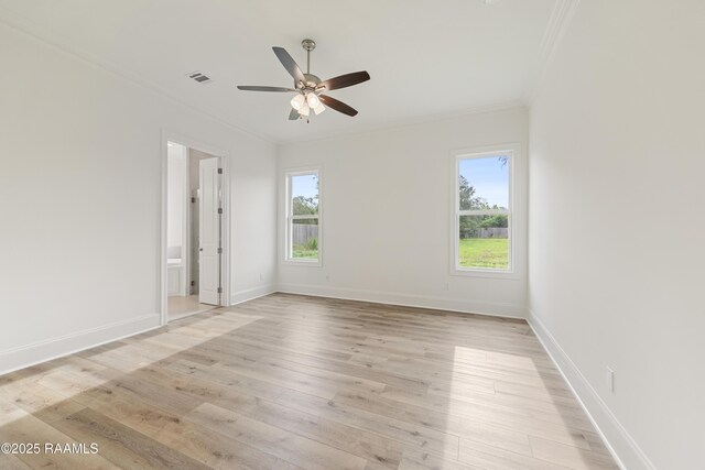 empty room featuring plenty of natural light, visible vents, ceiling fan, and ornamental molding