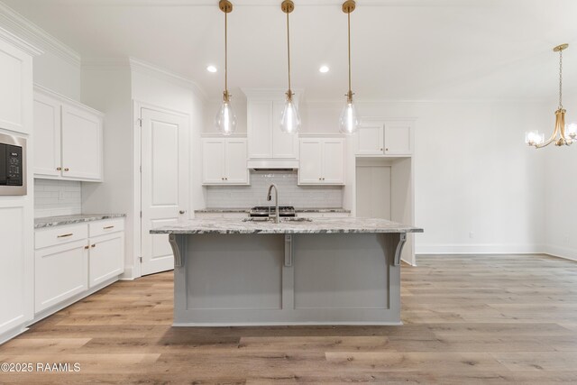 kitchen featuring backsplash, crown molding, and white cabinetry