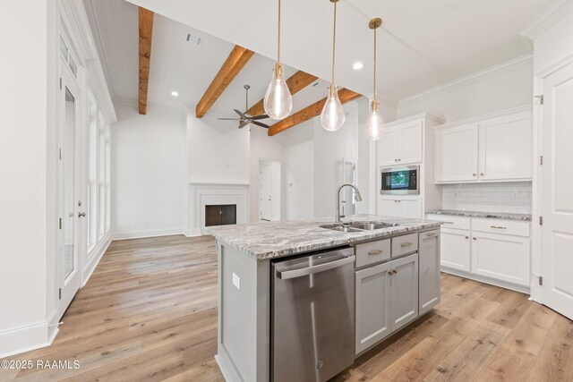 kitchen with built in microwave, dishwasher, a sink, decorative backsplash, and light wood-style flooring