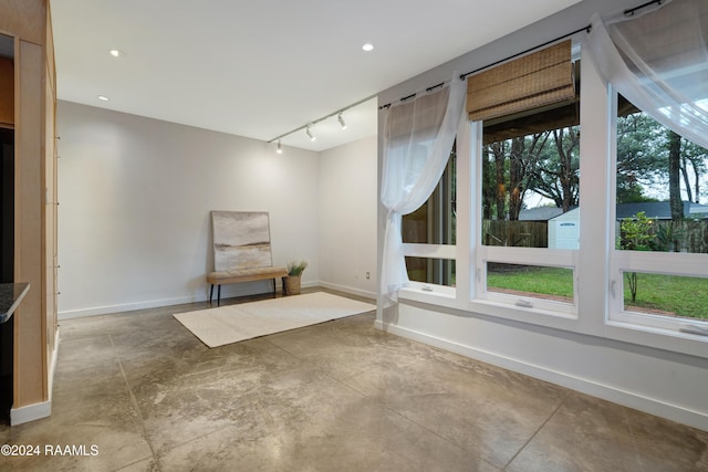 unfurnished room with concrete flooring and track lighting