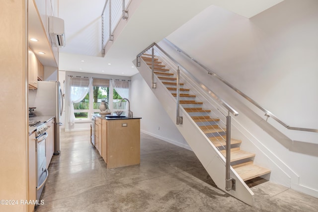 stairs featuring concrete flooring, a wall mounted AC, and sink