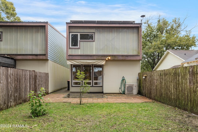 rear view of house with a lawn, a patio area, and ac unit