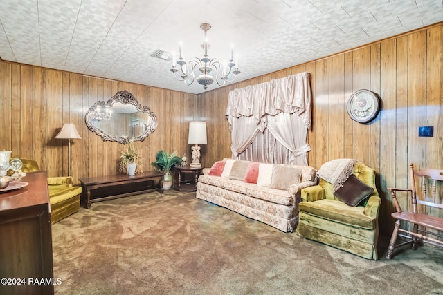 sitting room with a notable chandelier, carpet floors, and wooden walls