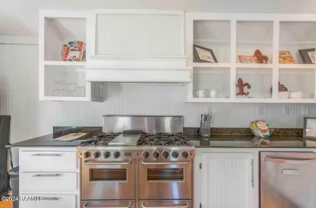 kitchen with custom exhaust hood, white cabinetry, and appliances with stainless steel finishes