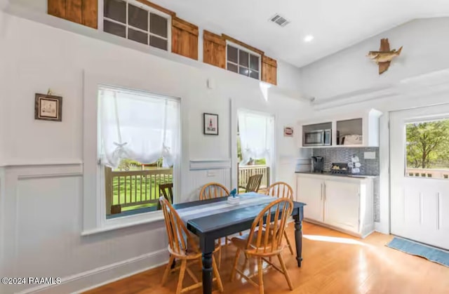 dining room with light hardwood / wood-style floors and lofted ceiling