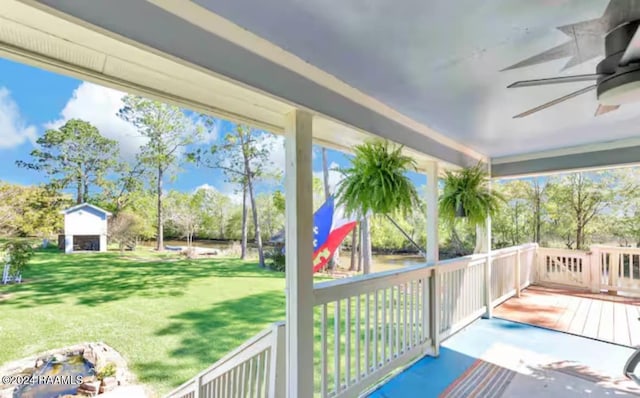 wooden terrace with ceiling fan and a yard