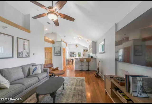 living room featuring ceiling fan, dark hardwood / wood-style flooring, and vaulted ceiling