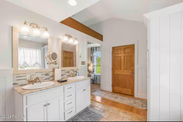 bathroom featuring tasteful backsplash, vanity, a healthy amount of sunlight, and hardwood / wood-style flooring