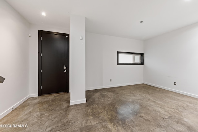 unfurnished room with concrete flooring