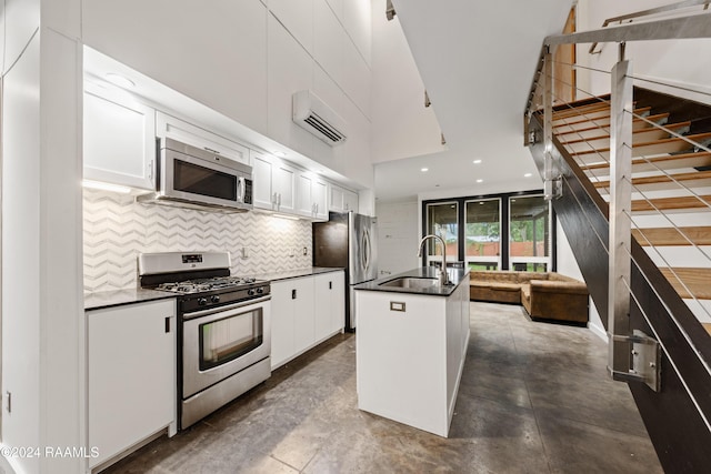 1611 W University Ave, Lafayette, LA 70506 - kitchen with stainless steel appliances, dark countertops, decorative backsplash, white cabinets, and an AC wall unit