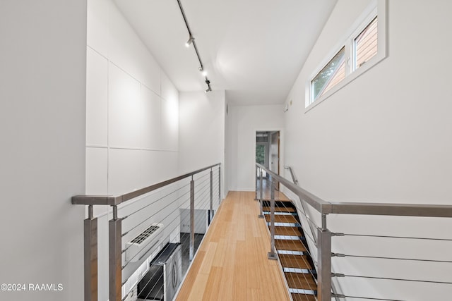 staircase featuring track lighting and hardwood / wood-style flooring