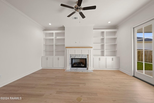 unfurnished living room with a premium fireplace, ornamental molding, and light hardwood / wood-style flooring