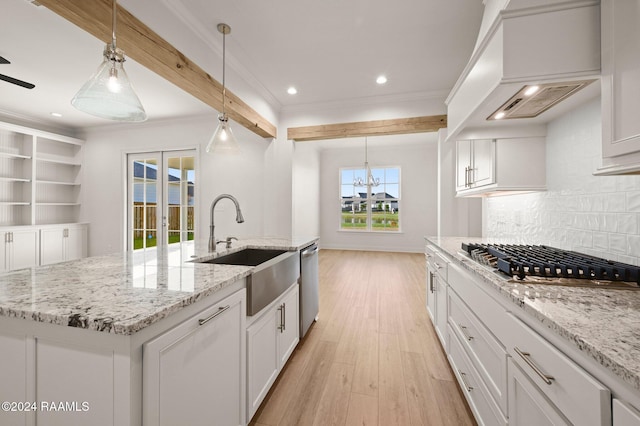 kitchen featuring custom exhaust hood, a kitchen island with sink, light hardwood / wood-style flooring, appliances with stainless steel finishes, and decorative light fixtures