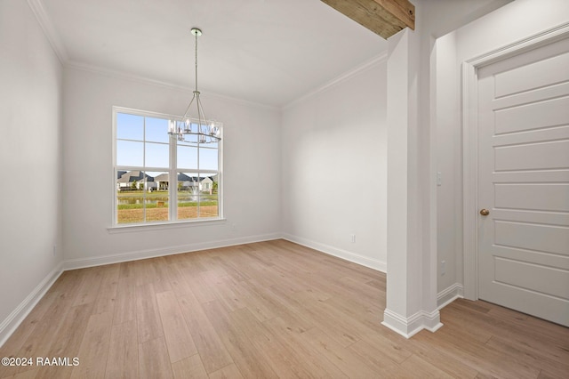 spare room with a chandelier, ornamental molding, and light hardwood / wood-style flooring