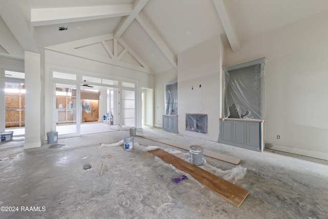 unfurnished living room featuring ceiling fan, beamed ceiling, and high vaulted ceiling