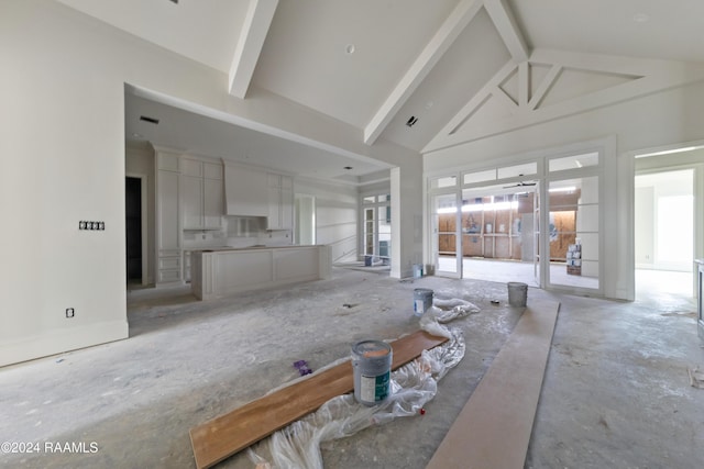 unfurnished living room featuring ceiling fan, beamed ceiling, and high vaulted ceiling