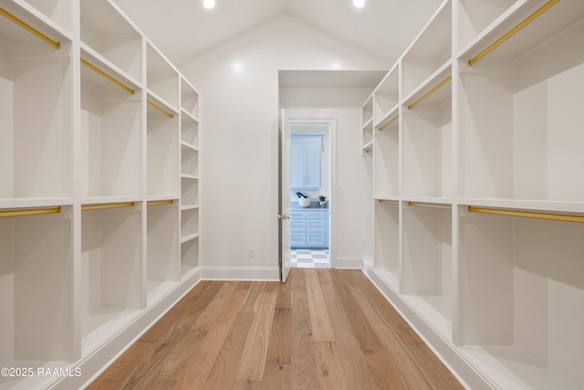 spacious closet with vaulted ceiling and wood finished floors