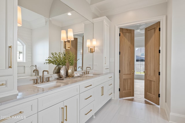 full bath featuring double vanity, recessed lighting, crown molding, and a sink