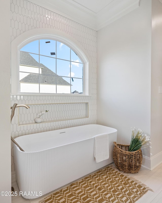 full bathroom with plenty of natural light, a freestanding bath, and ornamental molding