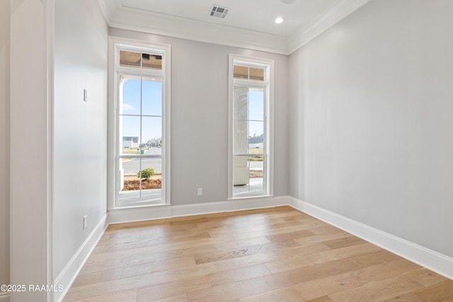 spare room featuring crown molding, light wood-style flooring, baseboards, and visible vents