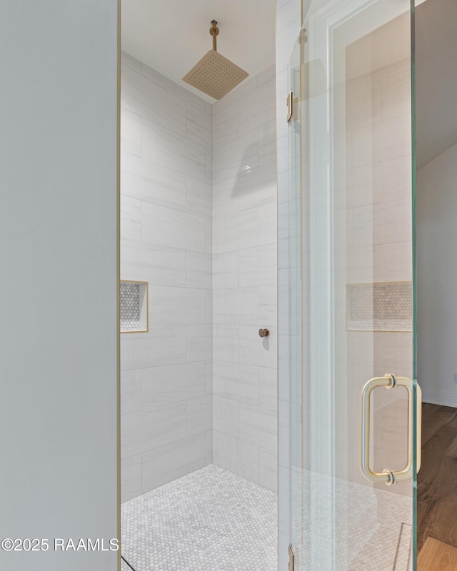 full bathroom featuring wood finished floors and a shower stall