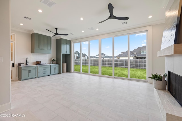 living area featuring visible vents, a fireplace, crown molding, and a ceiling fan