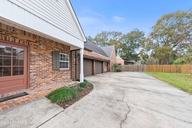 view of property exterior featuring a garage and a lawn