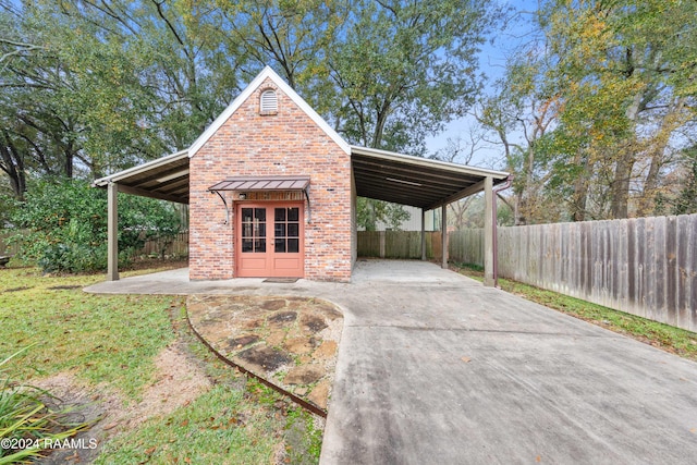 1013 Bayou Bend Cir, Breaux Bridge, LA 70517 - view of parking with concrete driveway, french doors, and an attached carport