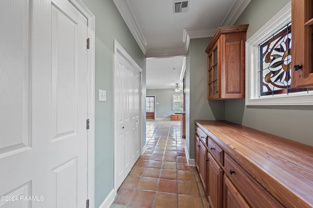 interior space featuring tile patterned floors and crown molding