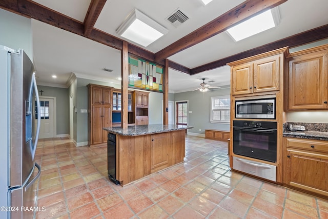 kitchen with ceiling fan, beamed ceiling, dark stone counters, appliances with stainless steel finishes, and ornamental molding