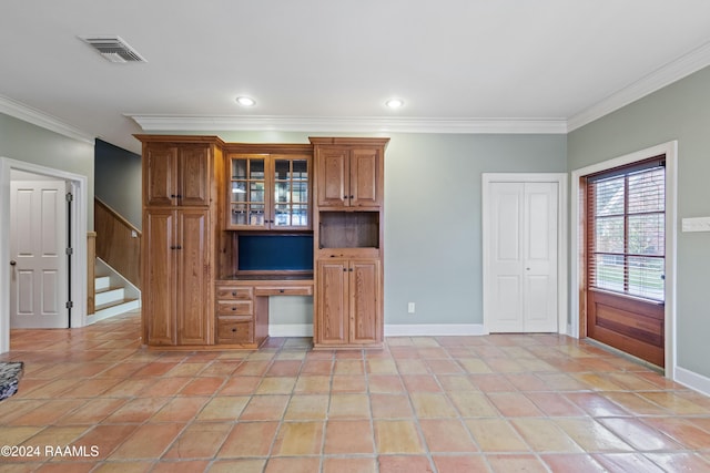 unfurnished living room featuring built in desk, ornamental molding, and light tile patterned floors