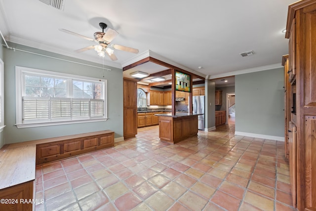 kitchen with ornamental molding, ceiling fan, light tile patterned floors, a center island, and stainless steel refrigerator
