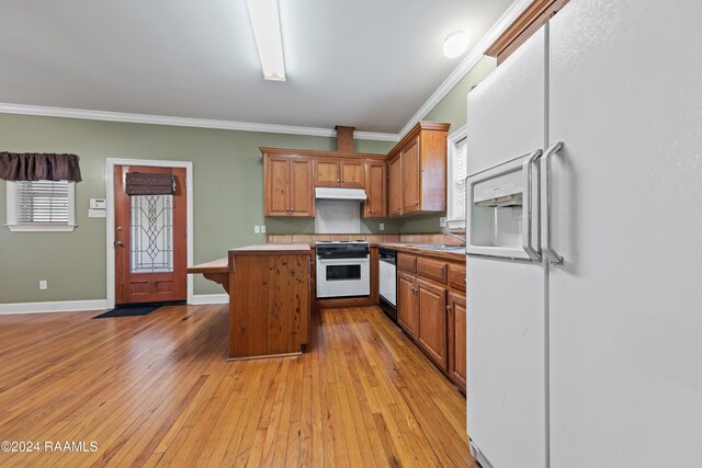 kitchen featuring white appliances, light hardwood / wood-style floors, ornamental molding, and sink